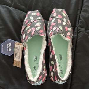 Toms Black and Pink Slip-ons with Glow in the Dark Holiday Lights Design